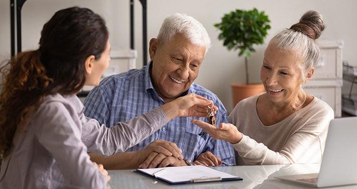 landlord handing keys to elderly couple